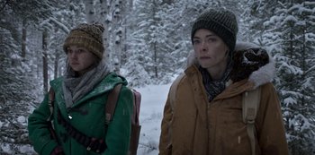 Movie still from “Black Summer” (2019), created by John Hyams – Two women in winter clothing standing next to each other in the snow; Close Up shot, Over the shoulder angle