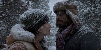 Movie still from “Black Summer” (2019), created by John Hyams – A man and a woman standing next to each other in the snow looking at one another; Close Up shot, Low angle