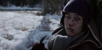 Movie still from “Black Summer” (2019), created by John Hyams – A woman in a purple hat holding something in her hand; Close Up shot, High angle