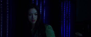 Movie still from “Blackhat” (2015), directed by Michael Mann – A woman is standing in a dark room; Close Up shot, Low angle