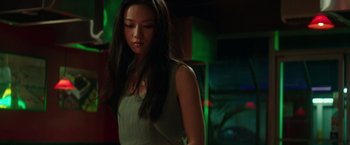 Movie still from “Blackhat” (2015), directed by Michael Mann – A woman standing in a dark room with long black hair; Medium shot, Over the shoulder angle
