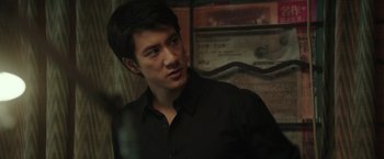 Movie still from “Blackhat” (2015), directed by Michael Mann – A man in a black shirt is looking at the camera; Close Up shot, Over the shoulder angle