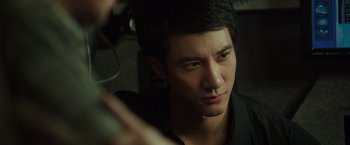 Movie still from “Blackhat” (2015), directed by Michael Mann – A man's face in a dark room; Close Up shot, Over the shoulder angle