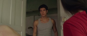 Movie still from “Blackhat” (2015), directed by Michael Mann – A man in a tank top standing in front of a mirror; Medium shot, Over the shoulder angle