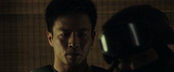 Movie still from “Blackhat” (2015), directed by Michael Mann – A person in a dark room; Close Up shot, Over the shoulder angle