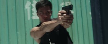 Movie still from “Blackhat” (2015), directed by Michael Mann – A man holding a gun in his hand; Close Up shot, Low angle