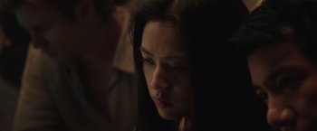Movie still from “Blackhat” (2015), directed by Michael Mann – A young woman with dark hair looking down; Close Up shot, Over the shoulder angle