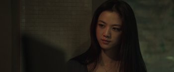 Movie still from “Blackhat” (2015), directed by Michael Mann – A woman with long dark hair is looking at the camera; Close Up shot, Over the shoulder angle