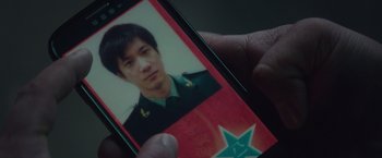 Movie still from “Blackhat” (2015), directed by Michael Mann – A person holding a cell phone in their hand; Extreme Close Up shot, High angle