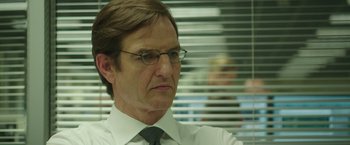 Movie still from “Blackhat” (2015), directed by Michael Mann – A person wearing glasses and a tie; Close Up shot, Over the shoulder angle