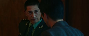 Movie still from “Blackhat” (2015), directed by Michael Mann – A man in a uniform looking at a man in a suit; Close Up shot, Over the shoulder angle