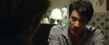 Movie still from “Blackhat” (2015), directed by Michael Mann – A man sitting in front of another man in front of a table; Close Up shot, Over the shoulder angle