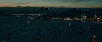 Movie still from “Blackhat” (2015), directed by Michael Mann – An airplane is flying over a large body of water at night; Extreme Wide shot, High angle