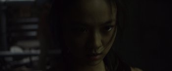 Movie still from “Blackhat” (2015), directed by Michael Mann – A young woman is looking into the camera; Close Up shot, Low angle