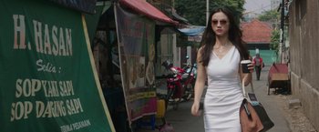 Movie still from “Blackhat” (2015), directed by Michael Mann – A woman walking down the street in a white dress; Medium shot, Low angle