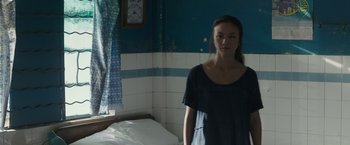 Movie still from “Blackhat” (2015), directed by Michael Mann – A woman standing next to a bed in a room; Medium shot, Low angle