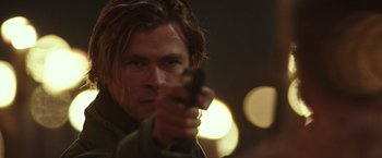 Movie still from “Blackhat” (2015), directed by Michael Mann – A person holding a gun; Close Up shot, Over the shoulder angle