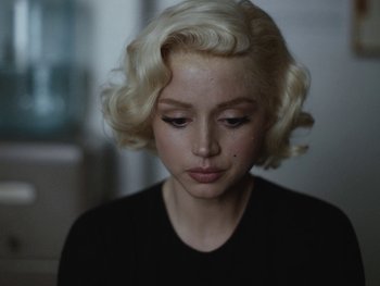 Movie still from “Blonde” (2022), directed by Andrew Dominik – A woman with blonde hair is looking down; Close Up shot, Over the shoulder angle