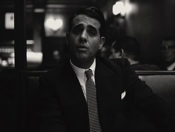 Movie still from “Blonde” (2022), directed by Andrew Dominik – A black and white photo of a man in a suit and tie; Close Up shot, Low angle