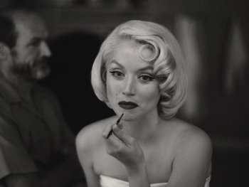 Movie still from “Blonde” (2022), directed by Andrew Dominik – A woman with blonde hair is putting lipstick on; Close Up shot, Over the shoulder angle
