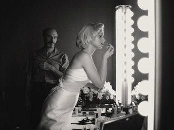 Movie still from “Blonde” (2022), directed by Andrew Dominik – A woman in a white dress brushing her teeth in front of a mirror; Medium shot, Low angle