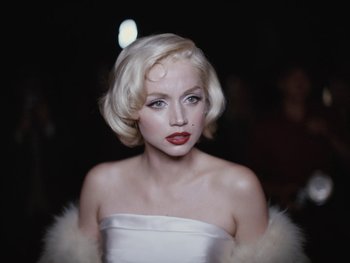 Movie still from “Blonde” (2022), directed by Andrew Dominik – A woman with blonde hair wearing a white dress; Close Up shot, Low angle