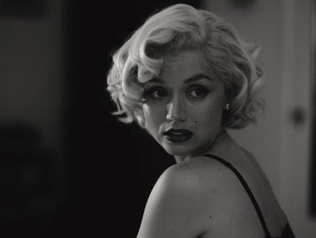 Movie still from “Blonde” (2022), directed by Andrew Dominik – A black and white photo of a woman in a black dress; Close Up shot, Over the shoulder angle