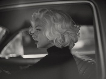 Movie still from “Blonde” (2022), directed by Andrew Dominik – A black and white photo of a woman in the back of a car; Close Up shot, Over the shoulder angle