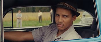 Movie still from “Loving” (2016), directed by Jeff Nichols – A man in a hat sitting in the back of a car; Close Up shot, Over the shoulder angle