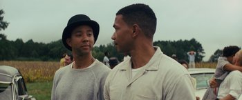 Movie still from “Loving” (2016), directed by Jeff Nichols – Two men standing next to each other on a field; Close Up shot, Over the shoulder angle
