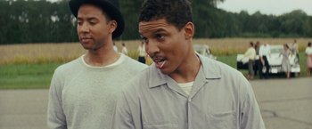 Movie still from “Loving” (2016), directed by Jeff Nichols – Two young men standing next to each other in a field; Close Up shot, Over the shoulder angle
