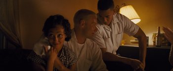 Movie still from “Loving” (2016), directed by Jeff Nichols – A man and two women sitting next to each other in a room; Medium shot, Over the shoulder angle