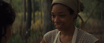Movie still from “Loving” (2016), directed by Jeff Nichols – A woman wearing a head scarf smiling for the camera; Close Up shot, Over the shoulder angle