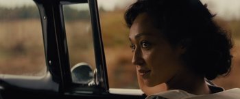 Movie still from “Loving” (2016), directed by Jeff Nichols – A woman sitting in the driver's seat of a car looking out the window; Close Up shot, Over the shoulder angle