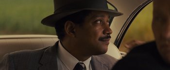 Movie still from “Loving” (2016), directed by Jeff Nichols – A person wearing a suit and a hat; Close Up shot, Over the shoulder angle