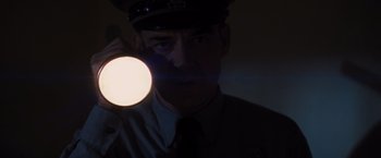 Movie still from “Loving” (2016), directed by Jeff Nichols – A man in a police uniform holding a flashlight; Close Up shot, Low angle