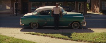 Movie still from “Loving” (2016), directed by Jeff Nichols – A man standing in front of an old car; Wide shot, Low angle
