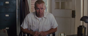 Movie still from “Loving” (2016), directed by Jeff Nichols – A person sitting in a chair near a window; Medium shot, Over the shoulder angle