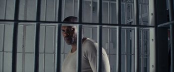 Movie still from “Loving” (2016), directed by Jeff Nichols – A man standing behind bars in a jail cell; Close Up shot, Low angle
