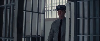 Movie still from “Loving” (2016), directed by Jeff Nichols – A police officer standing in front of a jail cell; Medium shot, Low angle