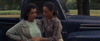 Movie still from “Loving” (2016), directed by Jeff Nichols – Two women standing next to each other in front of a truck; Medium shot, Over the shoulder angle
