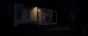 Movie still from “Loving” (2016), directed by Jeff Nichols – A person standing on the porch of a house at night; Wide shot, Low angle