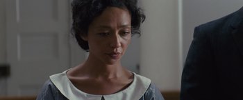 Movie still from “Loving” (2016), directed by Jeff Nichols – A person wearing a white and black dress; Close Up shot, Over the shoulder angle