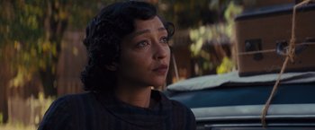 Movie still from “Loving” (2016), directed by Jeff Nichols – A woman is looking to her left while sitting in a parking lot; Close Up shot, Over the shoulder angle