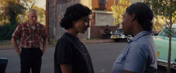 Movie still from “Loving” (2016), directed by Jeff Nichols – Two women standing on the side of the road talking to each other; Close Up shot, Over the shoulder angle