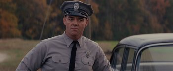 Movie still from “Loving” (2016), directed by Jeff Nichols – A man in a police officer's uniform and tie; Close Up shot, Low angle