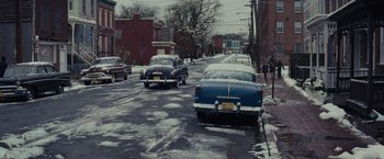 Movie still from “Loving” (2016), directed by Jeff Nichols – A couple of cars parked on the side of a road; Extreme Wide shot, High angle