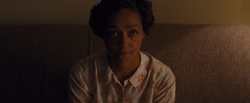 Movie still from “Loving” (2016), directed by Jeff Nichols – A woman sitting on a couch looking at the camera; Close Up shot, High angle