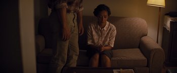 Movie still from “Loving” (2016), directed by Jeff Nichols – A woman sitting on a couch next to a man in front of a tv; Medium shot, High angle