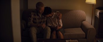 Movie still from “Loving” (2016), directed by Jeff Nichols – A man and a woman sitting on a couch together; Medium shot, High angle